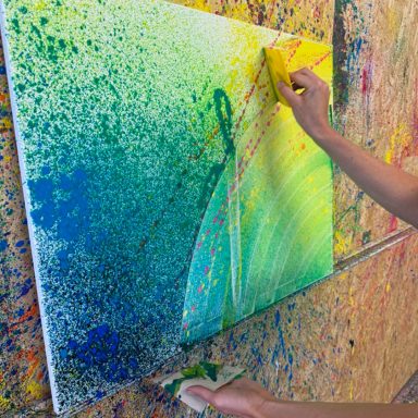 Leinwand bemalt und einer Hand mit Spachtel 