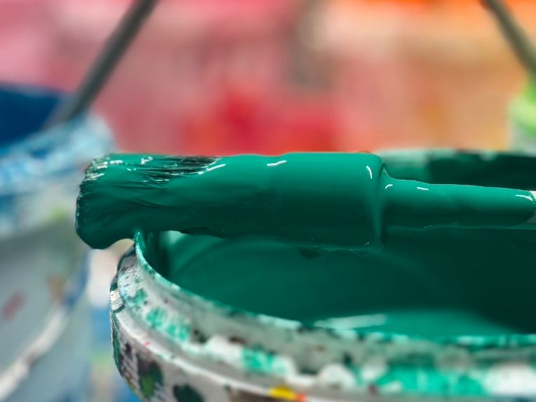 Ein Pinsel, der in grüne Farbe getaucht wurde.