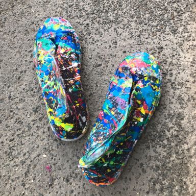 Schuhe sind mit bunter Farbe bespritzt