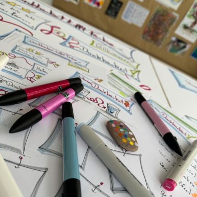 Blatt Papier, Filzstift und bemalter Stein